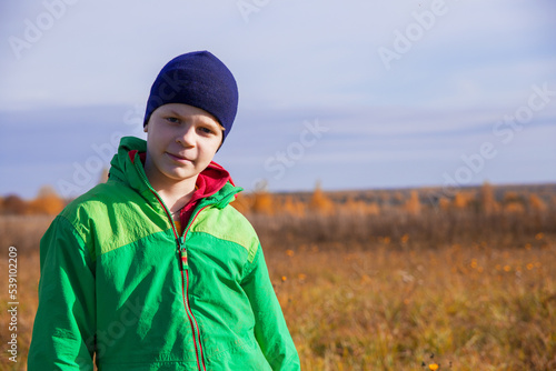 Defocused background. The boy walks in nature in golden autumn. © Sergei