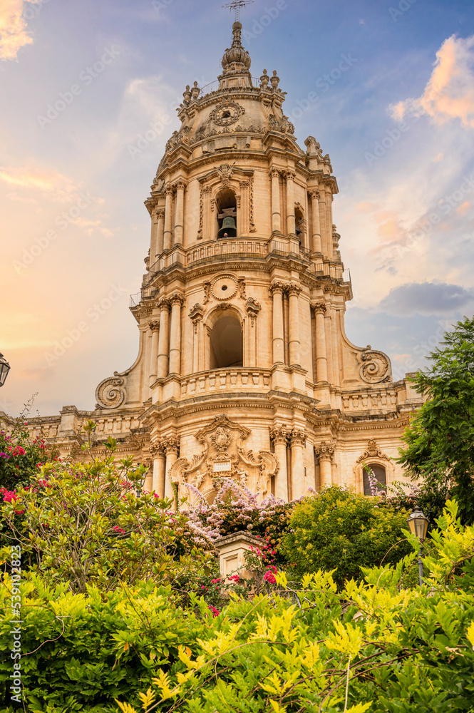 Colorful flowers and plants with the beautiful Cathedral of S. Giorgio di Modica in the background