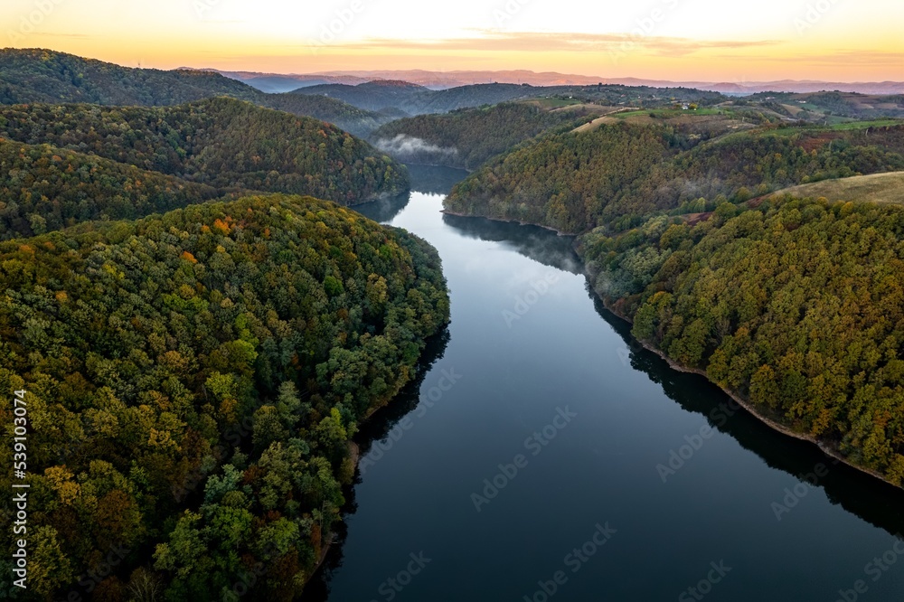 Obraz premium Colorful aerial view of Secu Lake in Caras-Severin - Romania, in the autumn, at sunrise. Scene captured from above, with a drone.