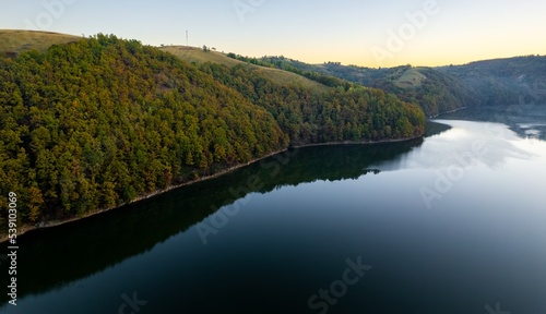 Colorful aerial view of Secu Lake in Caras-Severin - Romania, in the autumn, at sunrise. Scene captured from above, with a drone.