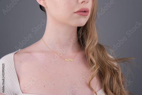 Gold initial necklace on neck of attractive white dress girl. Personalized necklace image. Jewelry photo for e commerce, online sale, social media