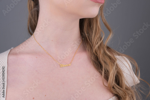 Gold initial necklace on neck of attractive white dress girl. Personalized necklace image. Jewelry photo for e commerce, online sale, social media photo