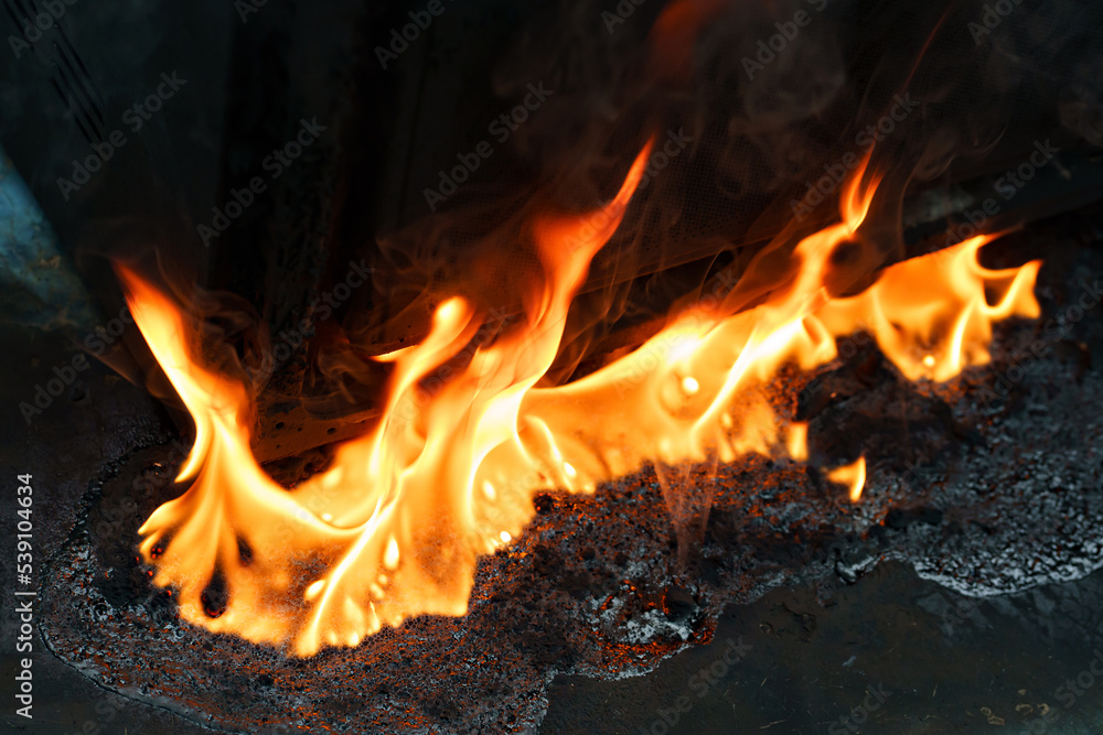fire and molten plastic on a black background. the concept of fire in the kitchen and malfunctions, breakdowns of electrical appliances and wiring, installation of fire safety systems. fire and molten plastic on a black background. the concept of fire in the kitchen and malfunctions, breakdowns of electrical appliances and wiring, installation of fire safety systems.
