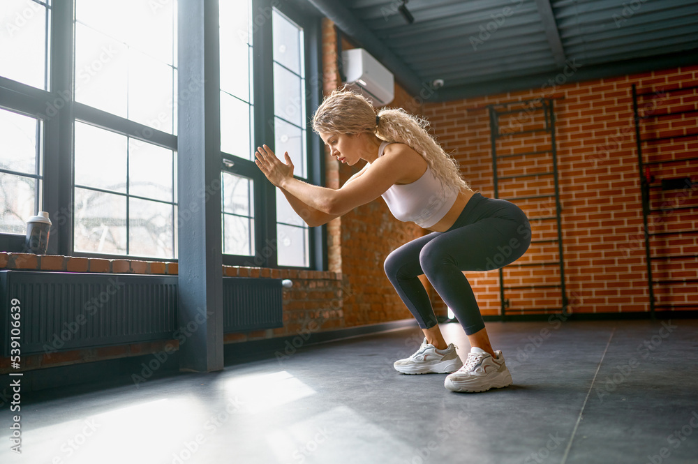 Woman training legs muscles with jump and squat Woman training legs muscles with jump and squat