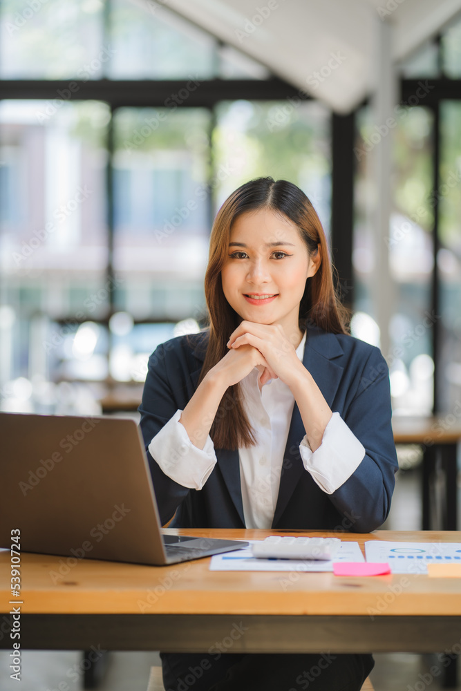 business woman or accountant who are using a calculator to calculate business data Accounting documents and laptop computer at the office business idea business woman or accountant who are using a calculator to calculate business data Accounting documents and laptop computer at the office business idea
