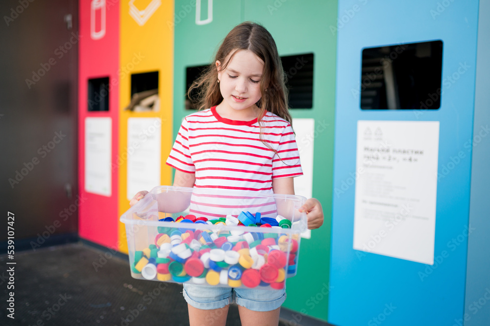 Kids collecting littered plastic bottlecaps and putting in recycling