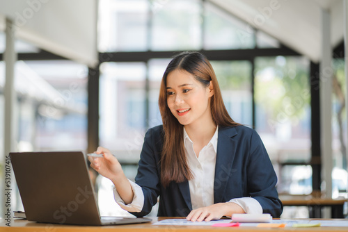 business woman or accountant who are using a calculator to calculate business data Accounting documents and laptop computer at the office business idea