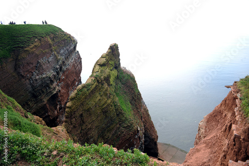 Scenic view of rock formations in cliff by seascape during summer