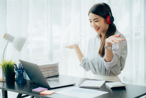 Asian woman enjoy listening to music and drinking coffee and laptop computer in the morning