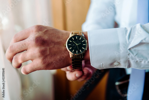 man putting clock on hand,groom getting ready in the morning