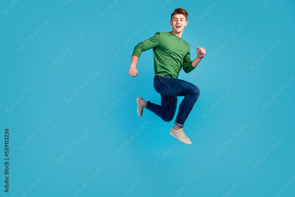 Full portrait of crazy excited handsome man jumping hurrying fast isolated on shine blue background