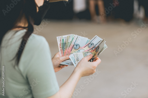 Asian women holding banknotes of Laos kip money the national currency of Laos.