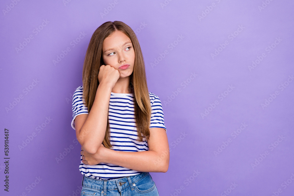 Photo of displeased upset girl straight hairdo wear striped t-shirt look empty space hand on cheekbone isolated on purple color background Photo of displeased upset girl straight hairdo wear striped t-shirt look empty space hand on cheekbone isolated on purple color background