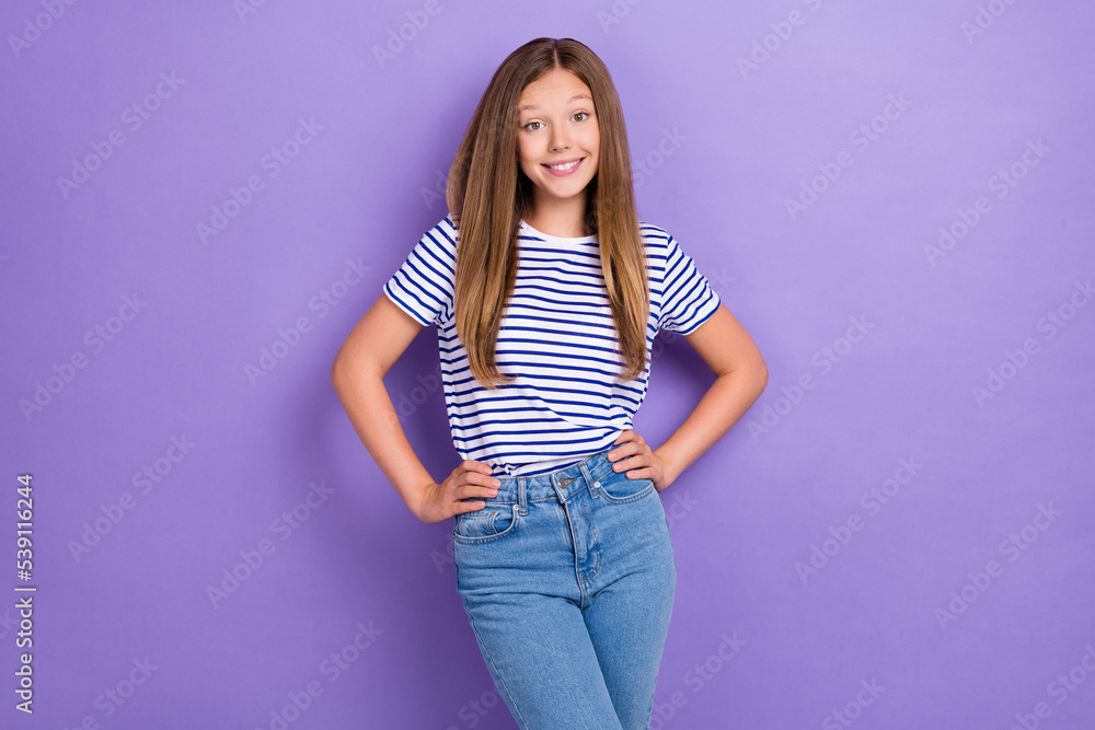Photo of funny optimistic cute girl with straight hairdo wear striped t-shirt hold arm on waist isolated on purple color background Photo of funny optimistic cute girl with straight hairdo wear striped t-shirt hold arm on waist isolated on purple color background
