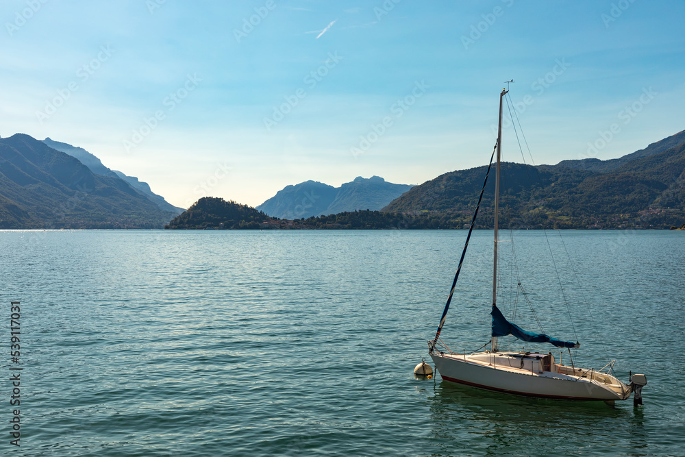 Sail boat moored on Lake Como with Bellagio on opposite lakeside