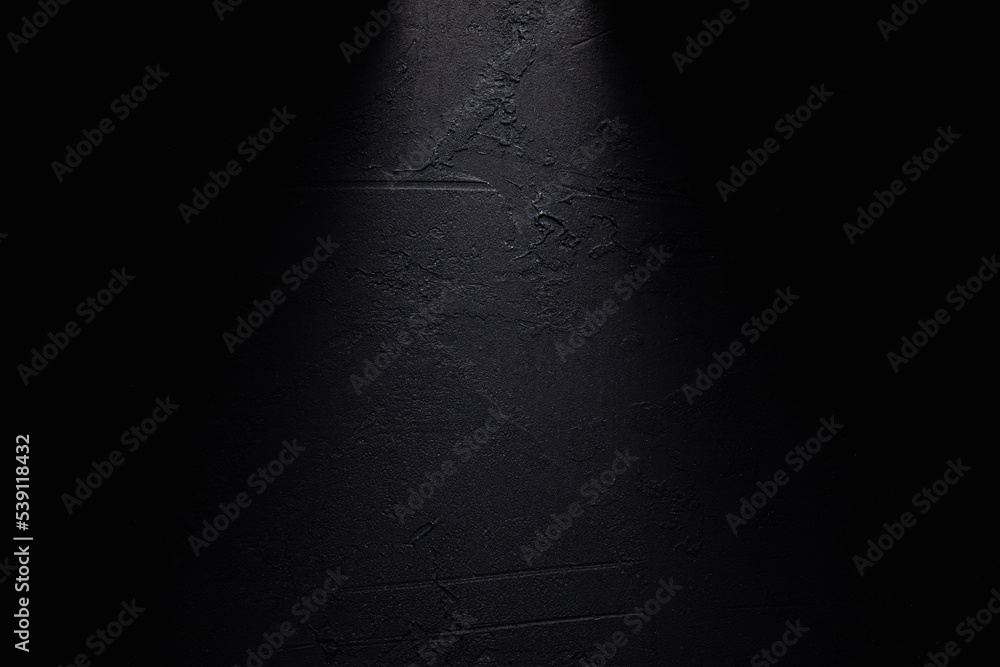Black textured background with a ray of light in the middle