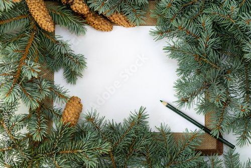 Paper and pencil writing space in frame of fir branches with cones, Christmas letter