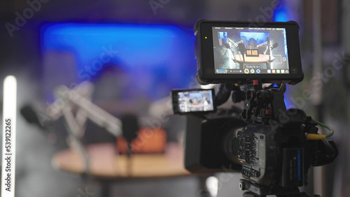 Professional camera video recording podcast set in kitchen surrounded with white led tubes