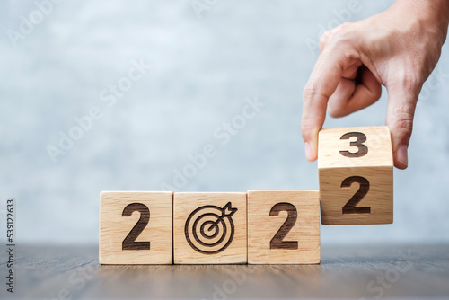hand flip 2022 to 2023 block with dartboard sign. Business Goal, Target, Resolution, strategy, plan, Action motivation, change, thinking, countdown and New Year start concepts