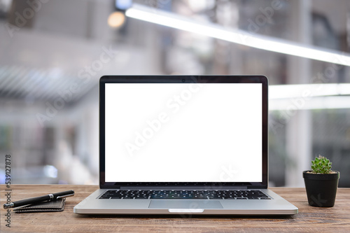 Desk Laptop with blank screen on table blur background with bokeh background that is used for editing
