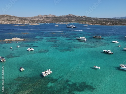 Aerial view of La Maddalena Island, Isola Giardinelli with the drone view of Caprera Island in Sardegna, Italy. Birds eye view of crystalline and turquoise water in north Sardinia, luxury yacht, boat. © AerialDronePics