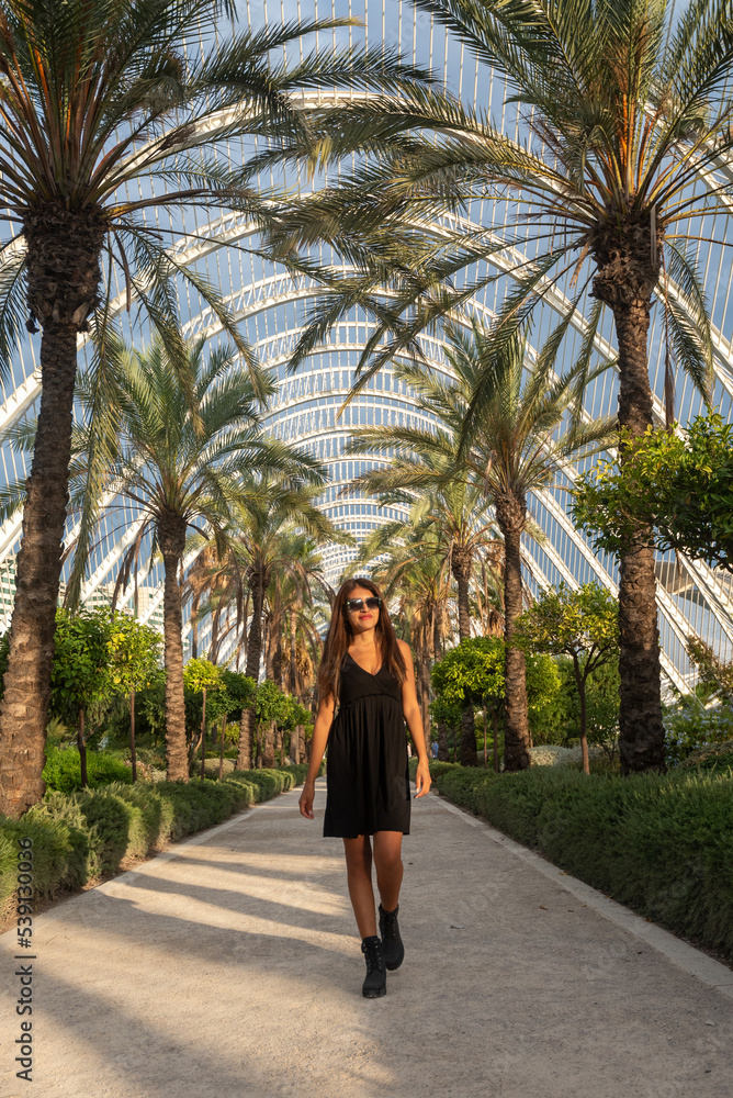 Beautiful woman in black dress in interior garden in Valencia, Spain
