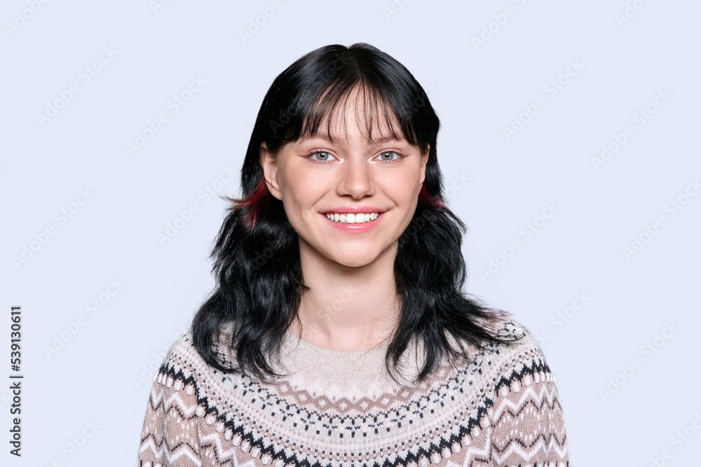 Young woman in winter sweater on light studio background Young woman in winter sweater on light studio background