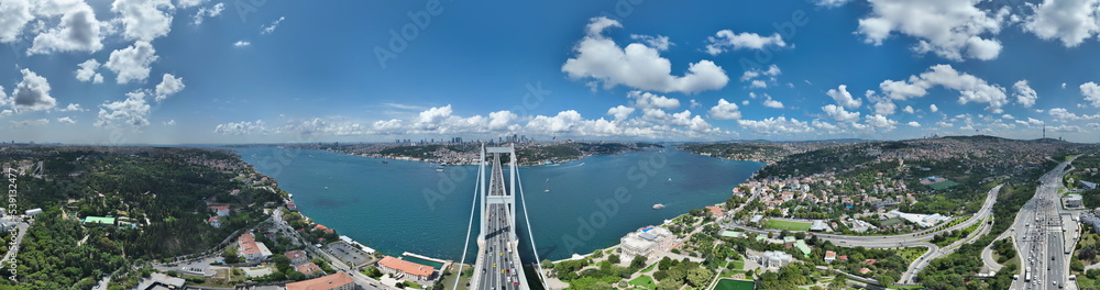 Istanbul Bosphorus Bridge and City Skyline in Background with Turkish Flag at Beautiful Sunset, Aerial slide orbiting and tracking shot