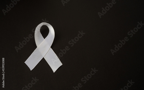 Top view of a white ribbon on a black background