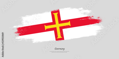 Happy National Day of Guernsey. National flag on artistic stain brush stroke background.