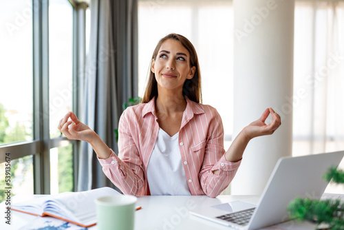 Obraz na plátne Calm woman relaxing meditating with laptop, no stress free relief at work concep