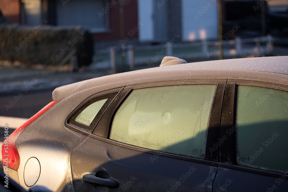 A portrait of the side of a car with frozen side windows during winter. The ice first needs to melt or be removed before the driver can safely start the journey. A portrait of the side of a car with frozen side windows during winter. The ice first needs to melt or be removed before the driver can safely start the journey.