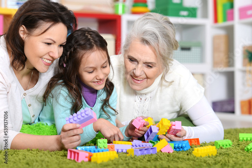 Cute girl playing with mom and grandma in cubes