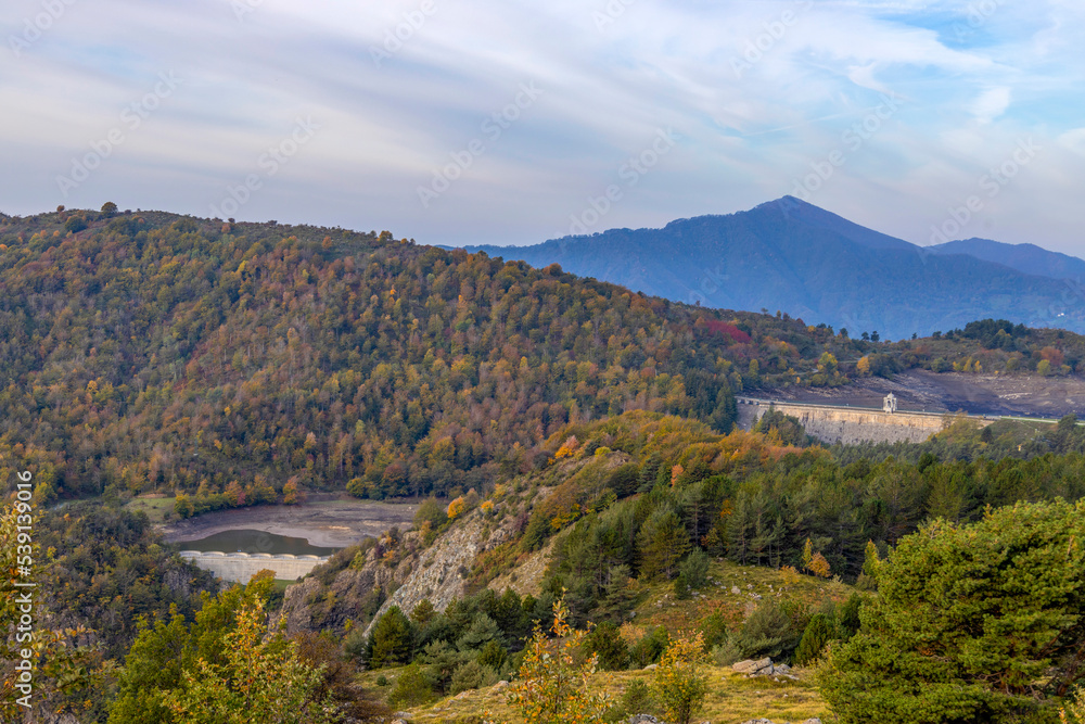 Autumn mountain landscape in Liguria, with the dam of the Giacopiane lake on the background, Genoa province, Italy