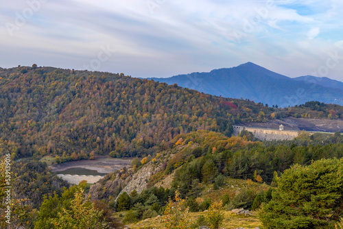 Autumn mountain landscape in Liguria, with the dam of the Giacopiane lake on the background, Genoa province, Italy