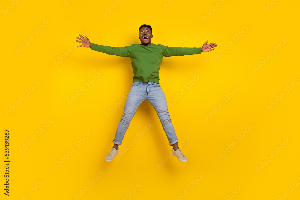 Full length body size view of attractive cheerful guy jumping fooling having fun isolated over vivid yellow color background