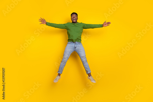 Full length body size view of attractive cheerful guy jumping fooling having fun isolated over vivid yellow color background