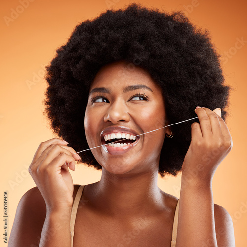 Φωτογραφία Flossing, dental and black woman cleaning teeth against an orange studio background