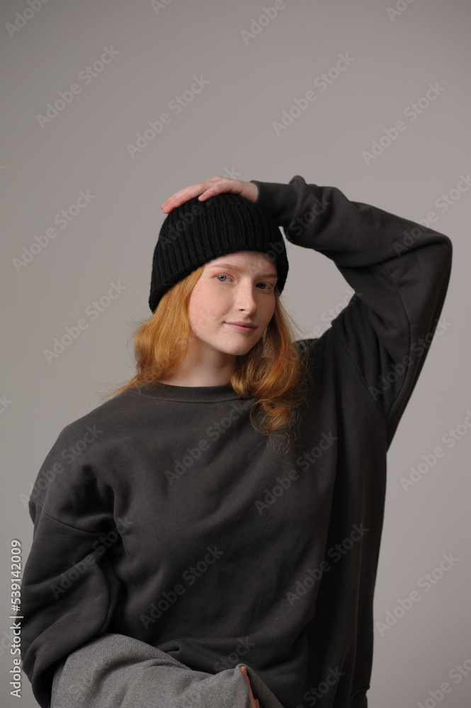 young girl model in black cap and grey jackett isolated on grey background. Product photo mockup for fashion brands and marketplaces. young girl model in black cap and grey jackett isolated on grey background. Product photo mockup for fashion brands and marketplaces.