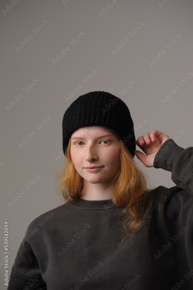 young girl model in black cap and grey jackett isolated on grey background. Product photo mockup for fashion brands and marketplaces.