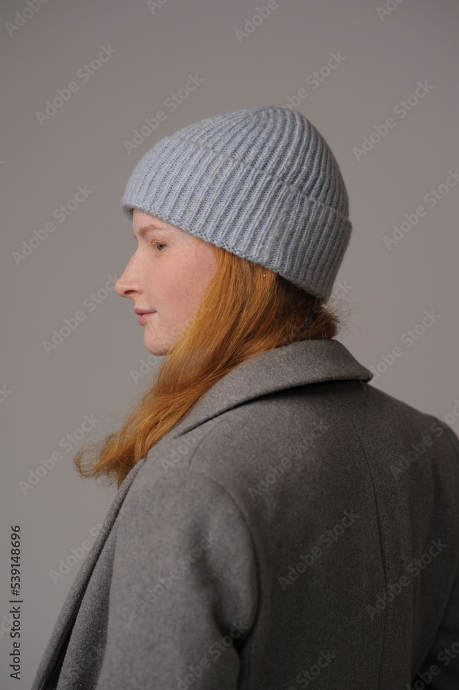young girl model in light blue cap and gray coat isolated on grey background. Product photo mockup for fashion brands and marketplaces. young girl model in light blue cap and gray coat isolated on grey background. Product photo mockup for fashion brands and marketplaces.