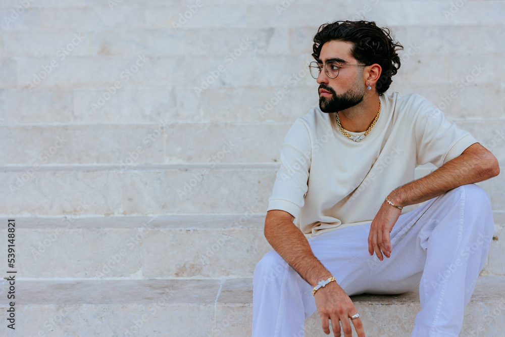 Casual man sitting on steps in city. Casual man sitting on steps in city.