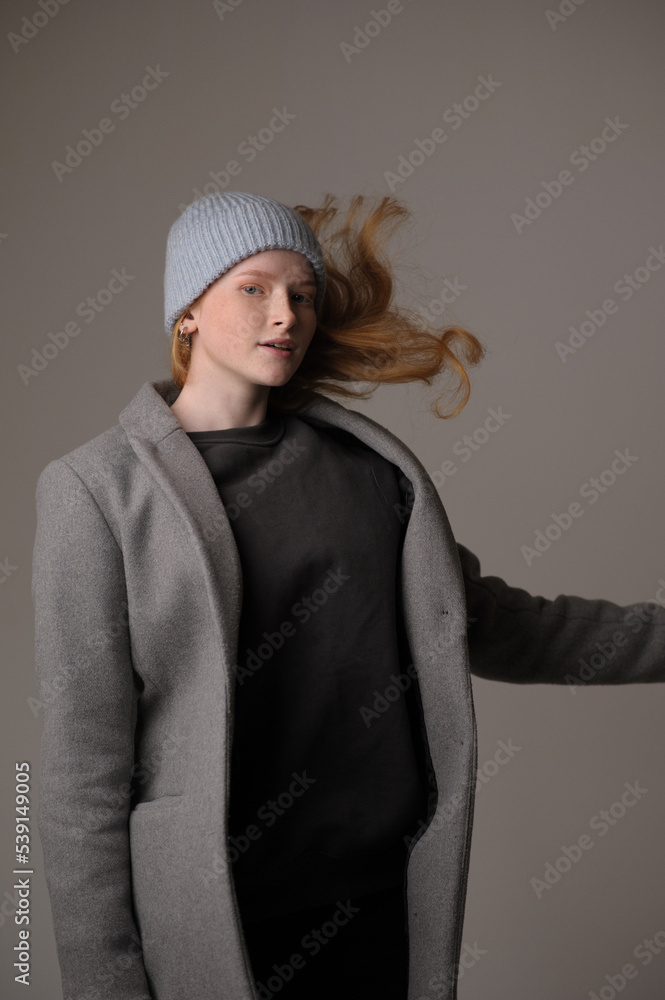 young girl model in light blue cap and gray coat isolated on grey background. Product photo mockup for fashion brands and marketplaces. young girl model in light blue cap and gray coat isolated on grey background. Product photo mockup for fashion brands and marketplaces.