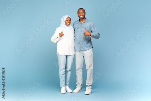 Schilderij op canvas Black Muslim Spouses Gesturing Thumbs Up Standing Over Blue Background