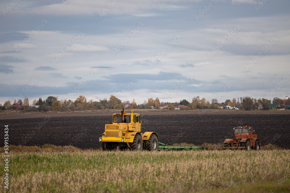 Fototapeta premium old model tractor working in the field.