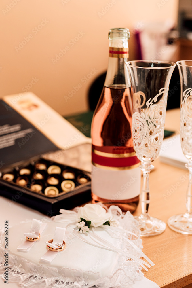 Wedding rings, champagne, sweets on the table. Wedding Day