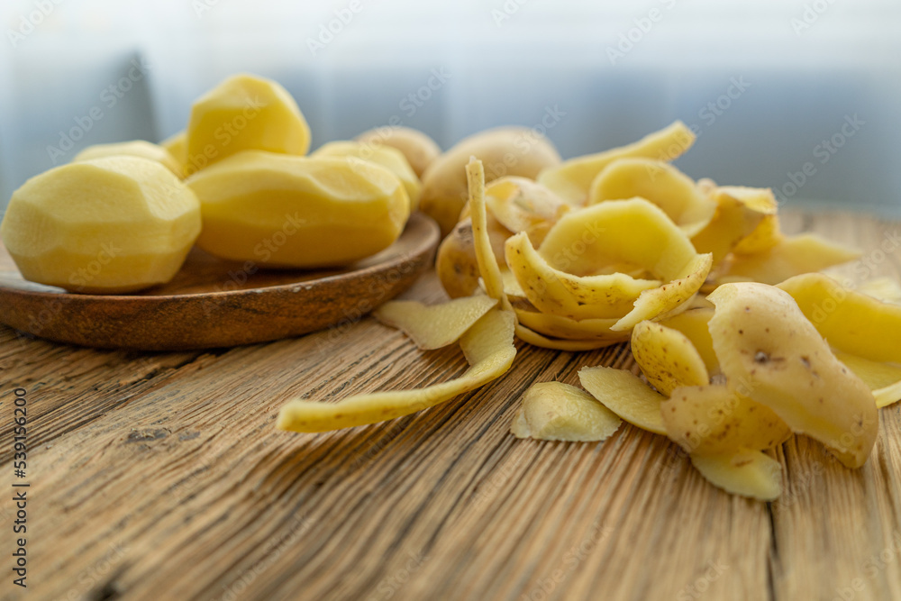 Peeling and Slicing Potatoes on Wooden Cutting Board