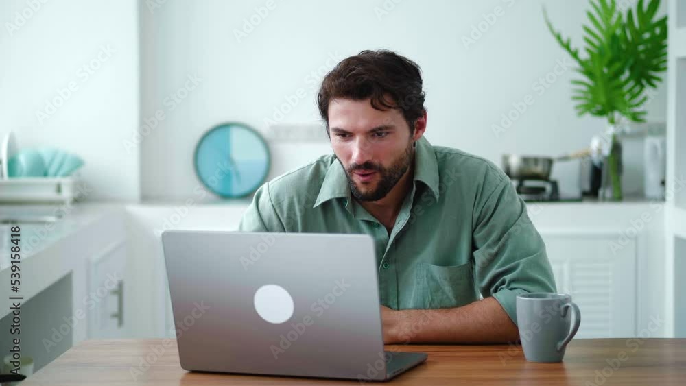 Charming successful young bearded multi-ethnic man expressing stupefaction and surprise, smiling a cheerful toothy smile while reading good news on laptop, achieving a successful deal on own business Charming successful young bearded multi-ethnic man expressing stupefaction and surprise, smiling a cheerful toothy smile while reading good news on laptop, achieving a successful deal on own business