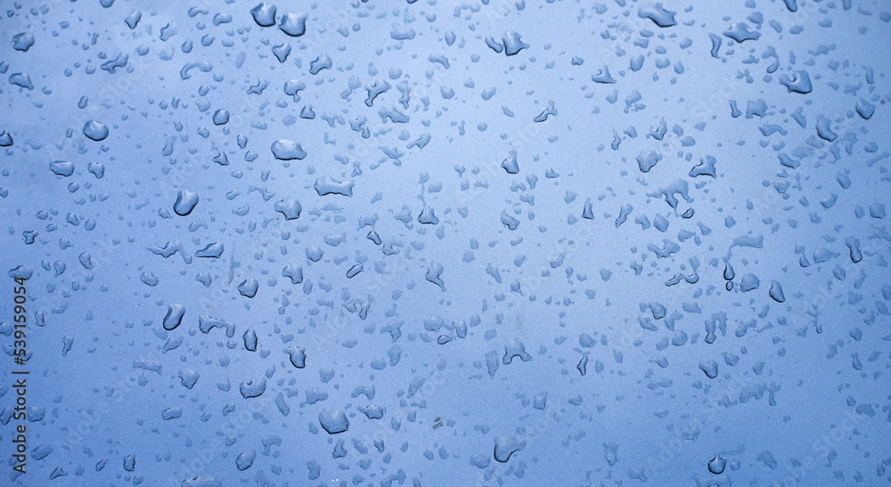 Photo of a dark metal car in raindrops. Moisture on the metal surface. Rain on an iron background. Photo of a dark metal car in raindrops. Moisture on the metal surface. Rain on an iron background.