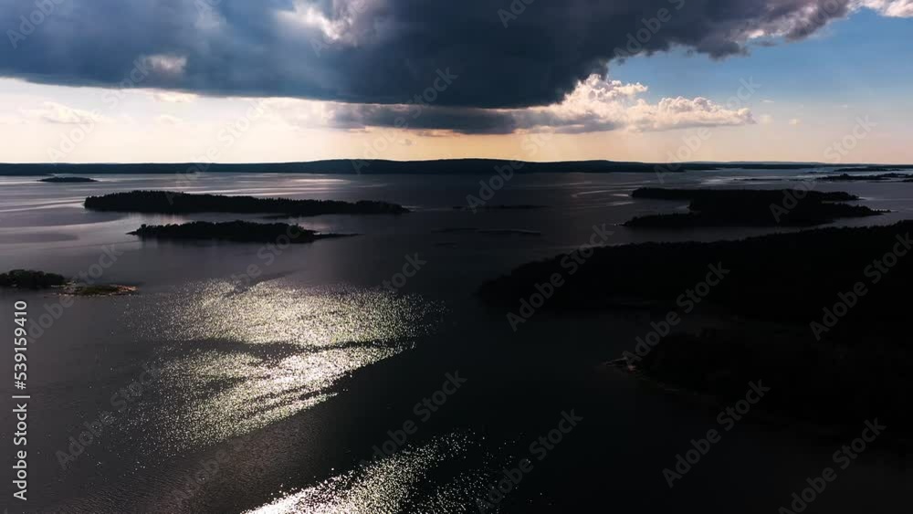 Aerial view of dramatic rain clouds shadowing islands in Ahvenanmaa, Finland - rising, drone shot Aerial view of dramatic rain clouds shadowing islands in Ahvenanmaa, Finland - rising, drone shot